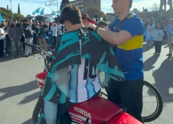 El peluquero que corta el pelo en la calle durante los festejos por los triunfos de Argentina